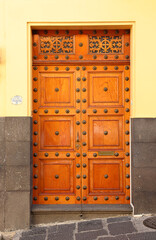Puerta de tableros de madera con detalles labrados y metálicos, México