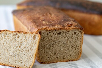 Rustic colonial rye bread. Well-lit image, clear selective focus on the details of the bread texture, conveying tradition, rusticity and homemade flavor.