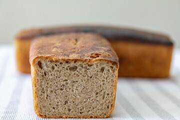 Rustic colonial rye bread. Well-lit image, clear selective focus on the details of the bread texture, conveying tradition, rusticity and homemade flavor.