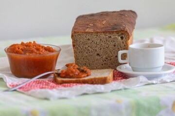 Rustic colonial rye bread, with chimia or pumpkin jam. Well-lit image, clear selective focus on the details of the texture of the bread and the jam, conveying tradition, rusticity and homemade flavor