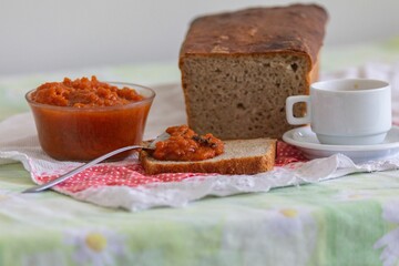 Rustic colonial rye bread, with chimia or pumpkin jam. Well-lit image, clear selective focus on the details of the texture of the bread and the jam, conveying tradition, rusticity and homemade flavor