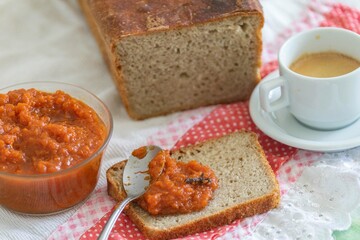 Rustic colonial rye bread, with chimia or pumpkin jam. Well-lit image, clear selective focus on the details of the texture of the bread and the jam, conveying tradition, rusticity and homemade flavor