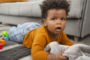 Multiracial toddler plays with toys on living room floor