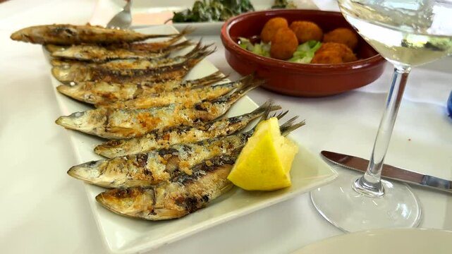 Fresh sardines and croquettes, dinner, tapas in restaurant in Spain, local cuisine