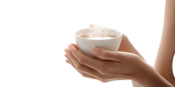 Womans hands holding a steaming cup of coffee indoors Concept of warmth, comfort, and relaxation with a hot beverage in a white ceramic mug