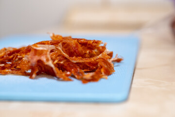 Shredded fried chorizo on blue cutting board
