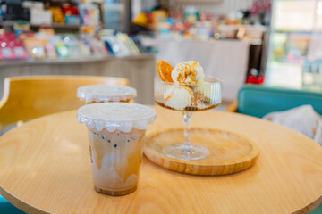 Close up glass ice coffee on wooden table at coffee shop in copy space concept.	