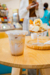 Close up glass ice coffee on wooden table at coffee shop in copy space concept.	