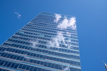 Clouds reflected in the windows of a modern office building.
