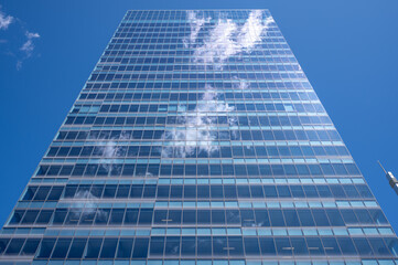 Clouds reflected in the windows of a modern office building.