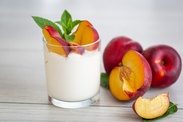 Ripe juicy nectarines in homemade yogurt on light wooden