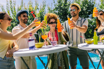 Young Friends Cheering with Cocktails by the Pool
