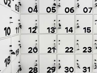 Rows of modern, white lockers with bold black numbers and keys, indicating a secure storage area in...