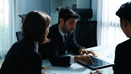 Back view of businessman working on laptop while team analysis data. Skilled marketing team writing marketing idea at meeting room. Group of diverse people brainstorm financial idea. Directorate.