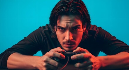 Close-up of a focused man with long hair gripping a controller under dual-toned lighting against a blue backdrop. The man's intense gaze and furrowed brow convey concentration.