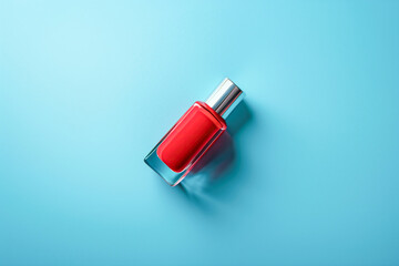 Red nail polish bottle on bright blue background