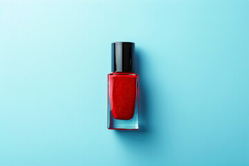 Red nail polish bottle on bright blue background