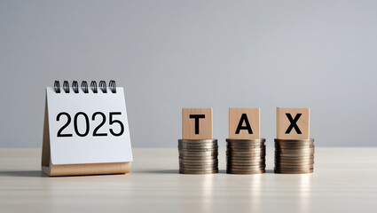 Tax Planning 2025 – Calendar with Coin Stacks and Wooden TAX Blocks on Desk