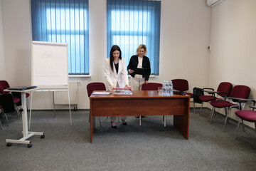 Two women meet to discuss a project and sign a contract.