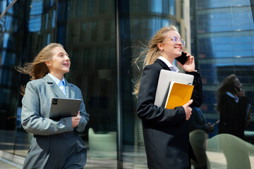 Business professionals enjoying a sunny day while discussing projects and making calls on a busy...