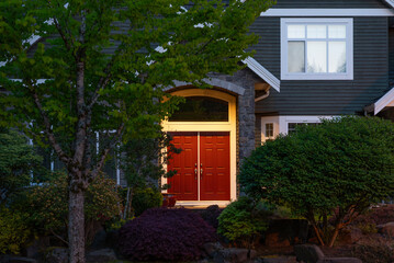 Entrance of luxury house with nice spring blossom landscape at night in Vancouver, Canada, North America. May 2025.