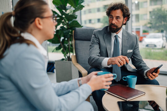 Business people discussing during coffee break in office lobby