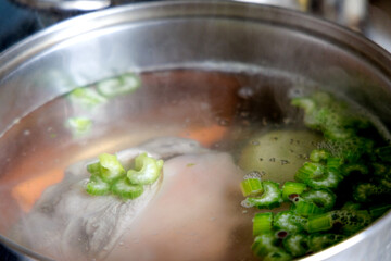 
We boil the pork leg and vegetables (celery and onion) in water in a metal pot.