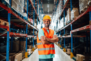 Warehouse worker smiling with crossed arms in logistics center