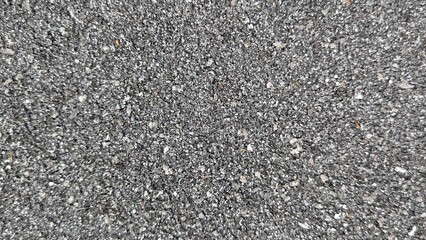 Close up view of a coarse asphalt road surface with small pebbles