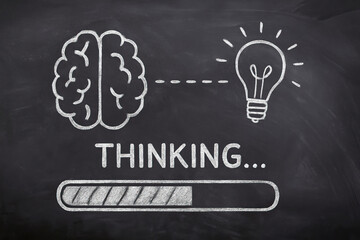 Thinking concept with brain, light bulb, and progress bar drawn with white chalk on blackboard, symbolizing idea generation and mental process
