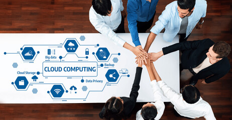 A diverse group of professionals collaborates on cloud computing solutions illustrated by graphics,...
