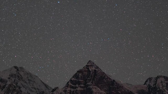 4K Zoom In Night lapse shot of stars moving in the sky above the snowy Himalayan mountain peak at Gondhla village in Lahaul and Spiti district, Himachal Pradesh, India. Stars move above the mountain.