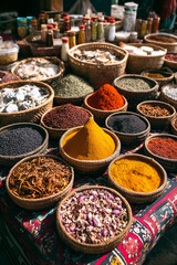colorful spice assortments in baskets on a patterned cloth at a market