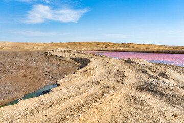 Dirt road along the pink salt lagoon in Paracas National Reserve, Peru