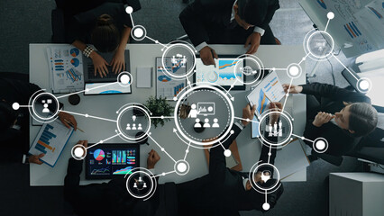 A dynamic business meeting showcasing collaboration among professionals, featuring data visualization tools and strategic planning in a modern office setting. Amity