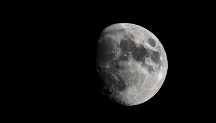 a dark detailed image of a moon with visible craters and surface textures illuminated faintly