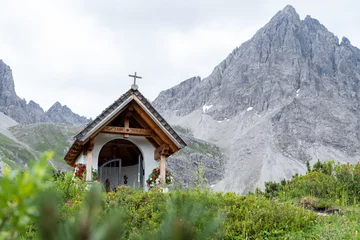 Selbstklebende Fototapeten Alpen Christian chapel in austrian alps with wooden roof in front of granite mountain 12  © El Benedikt