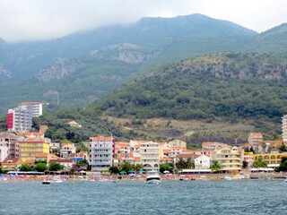 Picturesque Coastline of Budva With Hotels, Beach, and Marina Under Cloudy Skies