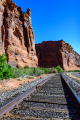 Railroad at the bottom of a canyon next to Layered Geological Formations of Red Rocks