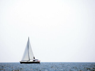 Sailing Yacht Gliding Across the Calm Sea Beneath a Clear Sky During Midday