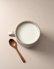 Overhead View of Milk in a Beige Mug with Wooden Spoon