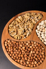 Tree minazhnitsa with walnuts, hazelnuts, pistachio on a black background