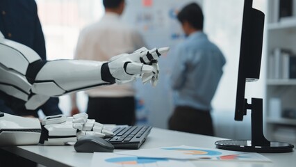 A robotic hand gestures over a keyboard, illustrating the blend of technology and human interaction...