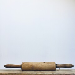 Vintage Wooden Rolling Pin on a Rustic Surface with White Background
