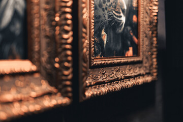 the interior of a restaurant, cafe, bar, paintings, in a gilded wooden frame, on a black wall, with a special ornament