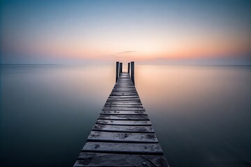 Obraz premium Wooden pier extending into a calm lake at sunset