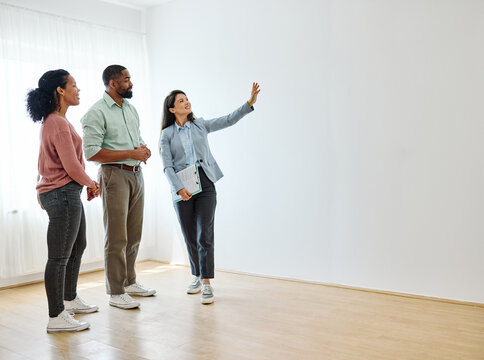 Female Real Estate Agent Selling And Showing The Modern Apartment To His Young Clients That Are Standing Next To Him In The Fancy Apartment