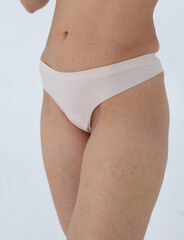 Beige women's briefs on the model. a woman in beige body shorts
