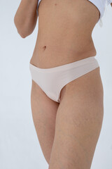 Beige women's briefs on the model. a woman in beige body shorts