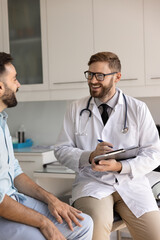 Positive young physician man asking patient about healthcare, disorder symptoms, wellness, writing...